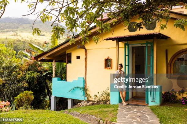 a woman enjoying a cup of coffee at her cottage in the mountains. - range of coffees stock pictures, royalty-free photos & images