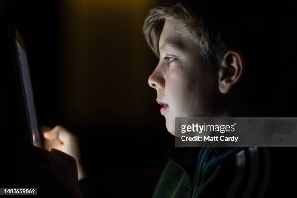 Year-old boy looks at a iPad screen on April 19, 2023 in Bath, England. The amount of time children spend on screens each day rocketed during the...