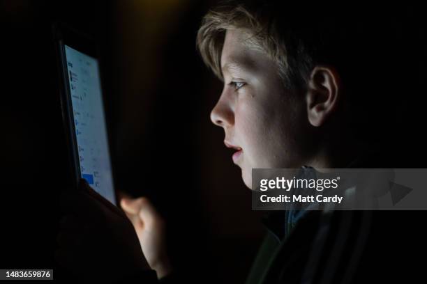 Year-old boy looks at a iPad screen on April 19, 2023 in Bath, England. The amount of time children spend on screens each day rocketed during the...