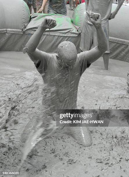 Tourists play in a pool of mud during the 15th Boryeong mud festival at Daecheon swimming beach in Boryeong, 190 kilometers southwest of Seoul on...