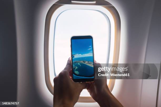 man taking photo through airplane window - palawan island stock pictures, royalty-free photos & images