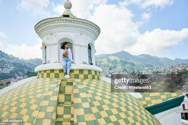 young woman sitting on dome at cathedral of quito - quito stock-fotos und bilder