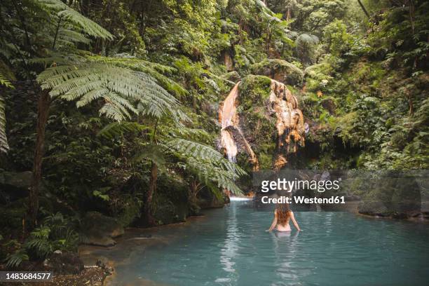 redhead young woman swimming in lake - azores people stock pictures, royalty-free photos & images