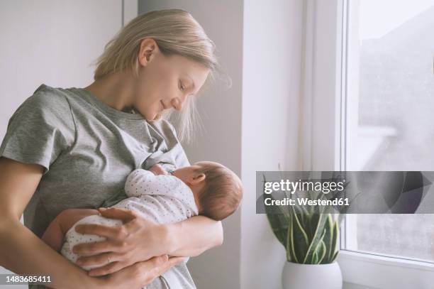mother breastfeeding baby boy at home - lactating women stock pictures, royalty-free photos & images