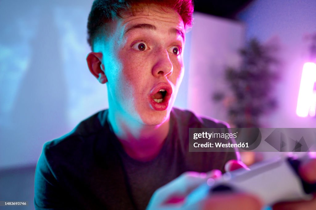 Man with facial expression playing leisure game at home