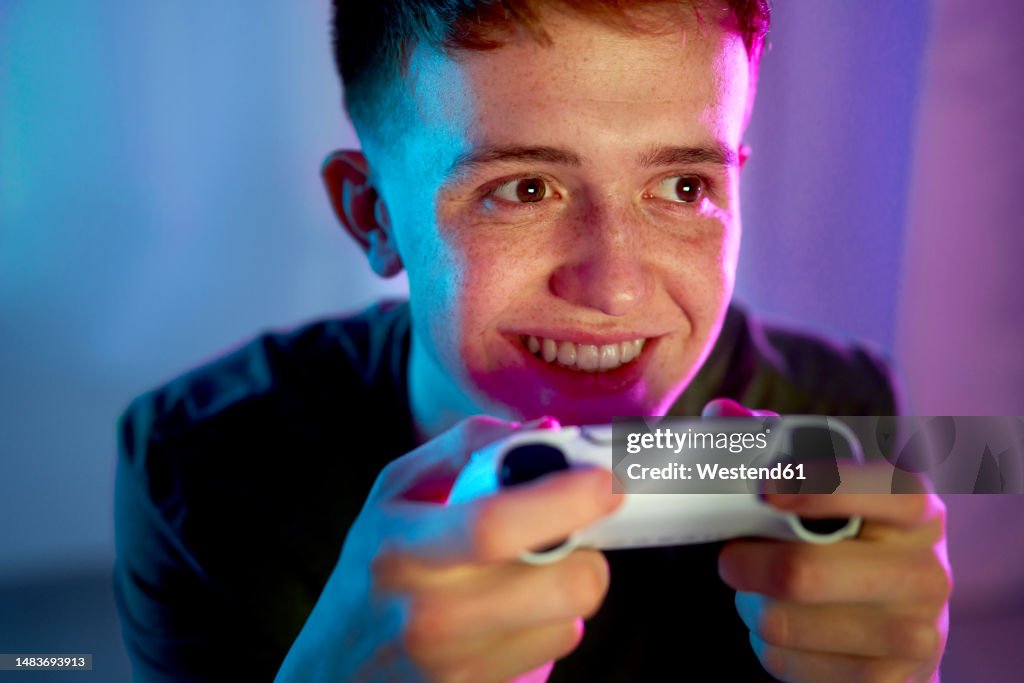 Happy young man playing video game