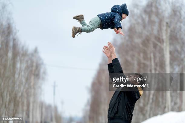playful father throwing son in air - dad throwing kid in air stockfoto's en -beelden