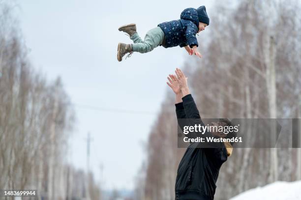 playful father throwing son in air - dad throwing kid in air imagens e fotografias de stock