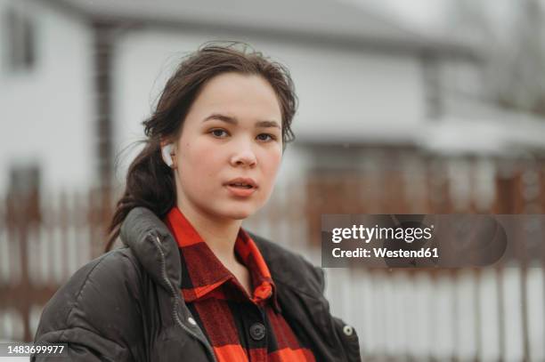 teenage girl wearing wireless earphones listening to music - 14 year old brunette girl stock pictures, royalty-free photos & images