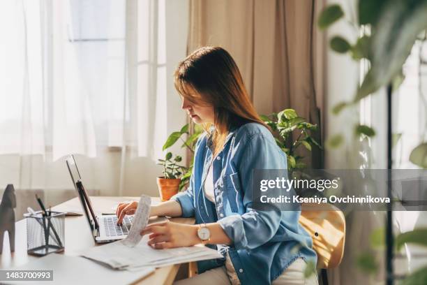 top view close up woman calculating bills, money, loan or rent payments, using laptop, online banking service, sitting at table, female holding receipt, planning budget, managing expenses, finances - credit score stock pictures, royalty-free photos & images