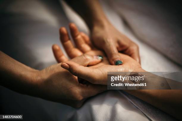 massage therapist massaging woman's hand - pressure point fotografías e imágenes de stock