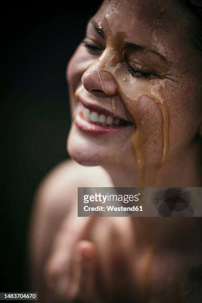 happy woman with liquid on face at health spa - ayurveda stock-fotos und bilder