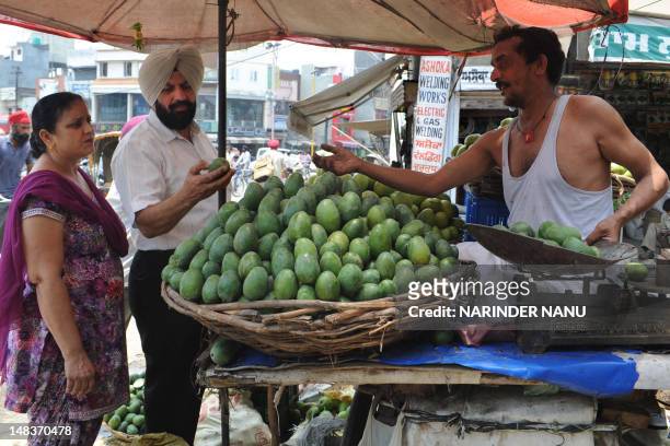 An Indian vendor sells raw mangoes which are used for pickles at the road side in Amritsar on July 15, 2012. Although India is the world's largest...