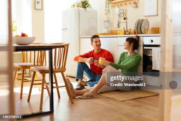 happy couple spending leisure time in kitchen - sitting on floor fotografías e imágenes de stock