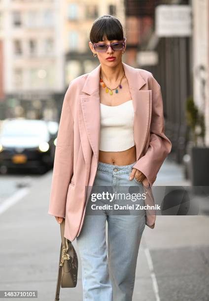 Katya Tolstova is seen wearing Tibi oversized jacket, MVP Wardrobe high-waisted denim palazzo pants, Crystal Haze nostalgia bear necklace, Louis...