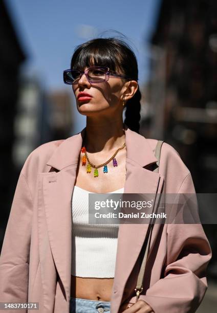 Katya Tolstova is seen wearing Tibi oversized jacket, MVP Wardrobe high-waisted denim palazzo pants, Crystal Haze nostalgia bear necklace, Louis...