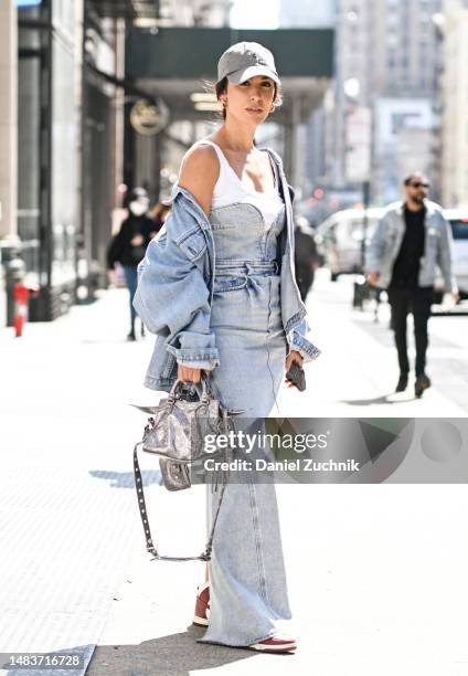 Dunja Jovanic is seen wearing a vintage denim jacket, and a H&M denim dress and white shirt with a tan hat, silver bag on April 20, 2023 in New York...