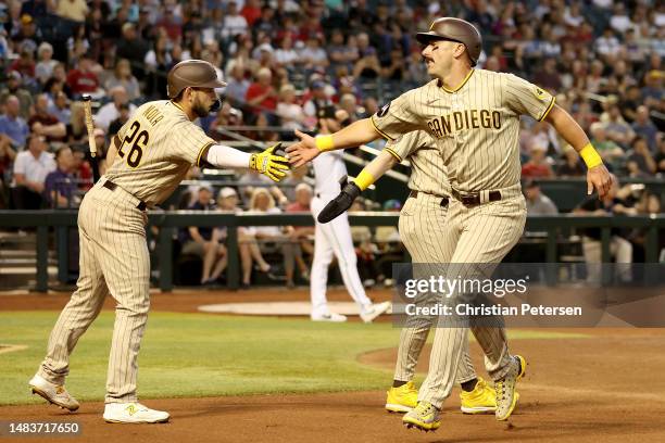 Matt Carpenter of the San Diego Padres high fives Austin Nola after scoring a run against the Arizona Diamondbacks during the second inning of the...