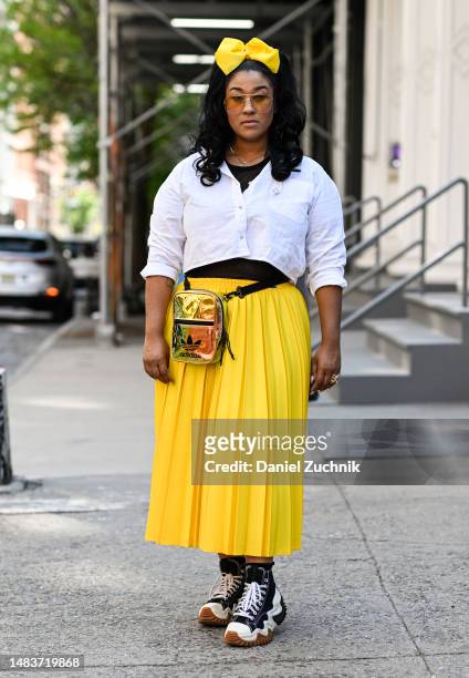 Ashley Benner is seen wearing a white shirt, Lacoste yellow skirt, Converse sneakers, gold Adidas bag and yellow bow on April 20, 2023 in New York...