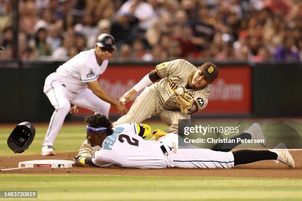 Geraldo Perdomo of the Arizona Diamondbacks safely slides into third base ahead of the tag from infielder Manny Machado of the San Diego Padres...