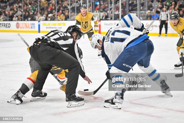 Adam Lowry of the Winnipeg Jets faces off with Chandler Stephenson of the Vegas Golden Knights during the first period in Game Two of the First Round...