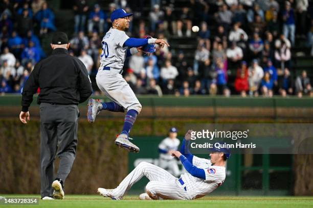Mookie Betts of the Los Angeles Dodgers turns a double play in the eighth inning against Cody Bellinger of the Chicago Cubs at Wrigley Field on April...