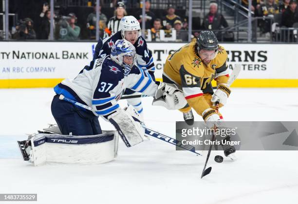 Connor Hellebuyck of the Winnipeg Jets defends an attempt by Mark Stone of the Vegas Golden Knights during the second period in Game Two of the First...