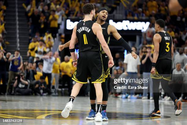 Klay Thompson congratulates Moses Moody of the Golden State Warriors after he made a basket against the Sacramento Kings in the second half of Game...