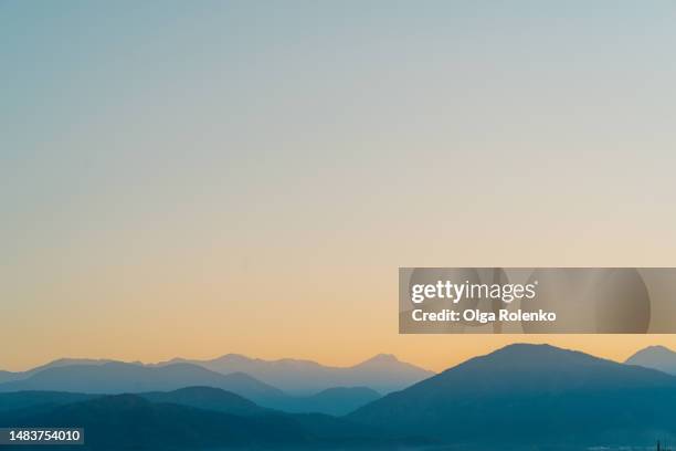 mountain ridge in yellow sunrise. blue and yellow mountain view against sunset sky. wallpaper background. copy space - high level summit stock pictures, royalty-free photos & images