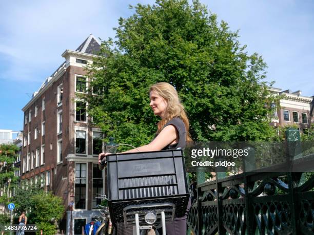portrait of a woman with a bicycle in amsterdam - amsterdam bike stockfoto's en -beelden