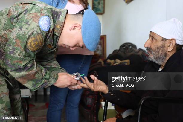 Medical personnel from the 21st Chinese peacekeeping force to Lebanon checks a patient's blood glucose level at a village on April 19, 2023 in...