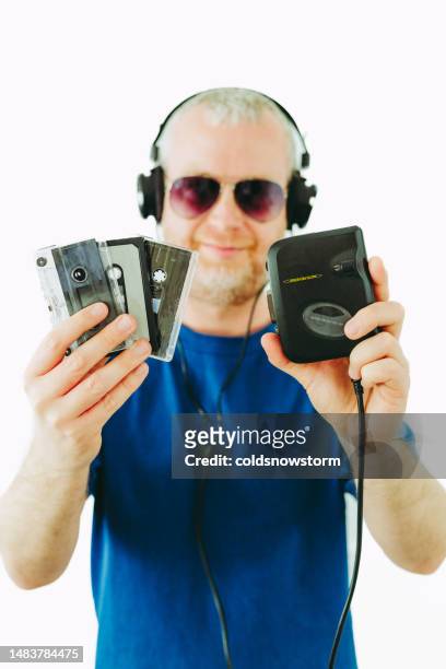 man listening to retro portable cassette player while holding cassette tapes - audio cassettes stock pictures, royalty-free photos & images