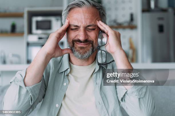 man suffering with a migraine. - frowning stock pictures, royalty-free photos & images