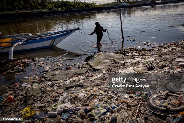 Fisherman docks his boat at a beach filled with plastic waste at Freedom Island on April 19, 2023 in Paranaque, Metro Manila, Philippines. The...