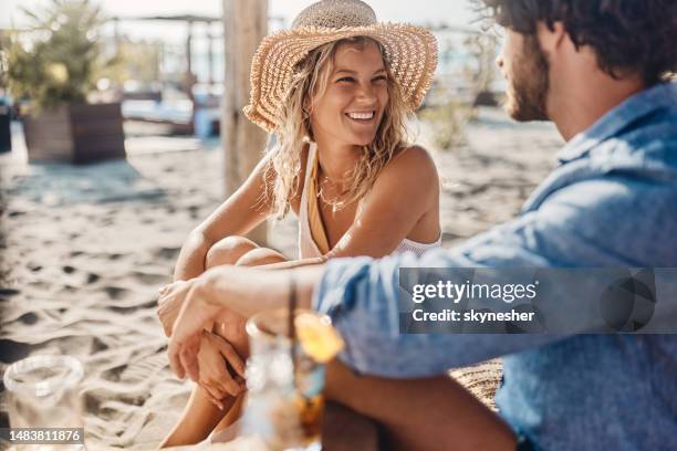 happy woman talking to her boyfriend in a beach café. - couple bar stock pictures, royalty-free photos & images