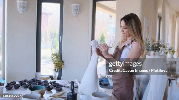the girl master processes the sculpture with sandpaper - stone sculptor stock pictures, royalty-free photos & images