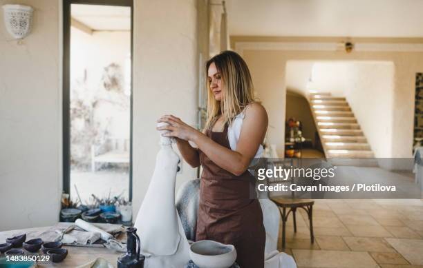 a sculptor girl works in a workshop - sculpteur photos et images de collection