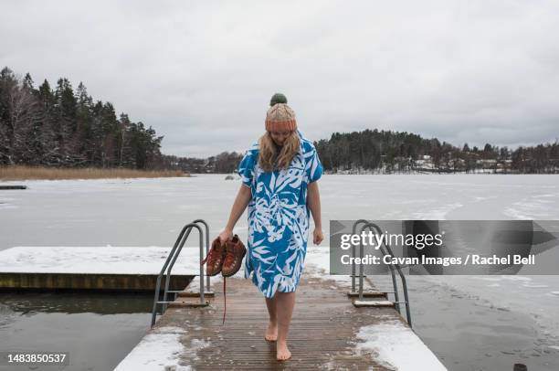 woman walking on a dock ready to go cold water swimming - ice swim woman foto e immagini stock