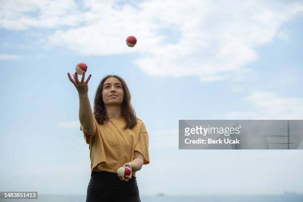 juggler young woman with blue sky. - juggling imagens e fotografias de stock