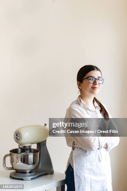 girl confectioner entrepreneur in her kitchen while cooking - achievement logo stock pictures, royalty-free photos & images