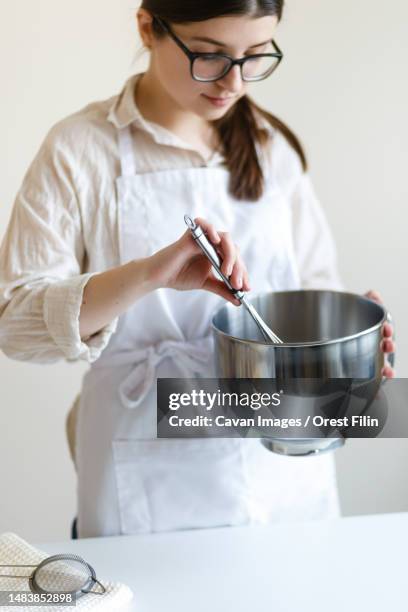 girl confectioner entrepreneur in her kitchen while cooking - achievement logo stock pictures, royalty-free photos & images
