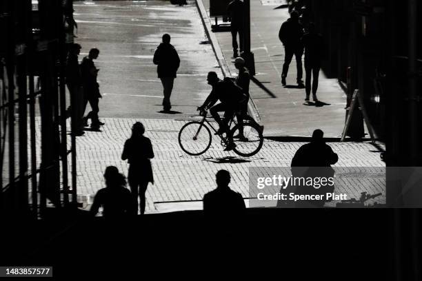 People walk by the New York Stock Exchange on April 21, 2023 in New York City. The Dow opened slightly up in morning trading after three consecutive...