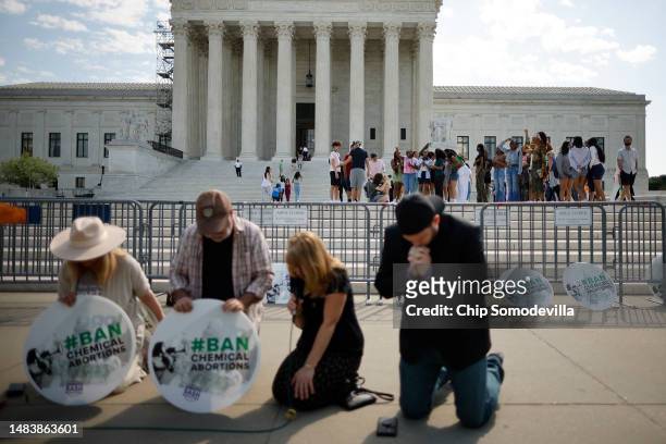 Young tourists shout their opposition to anti-abortion activists from the plaza in front of the U.S. Supreme Court as Katie Mahoney, Rev. Pat...
