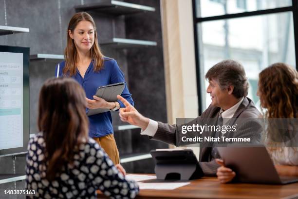 project status meetings help in brainstorming solutions as a team to running project smoothy. businessmen ask a question to a project manager in a meeting to follow up on the project status to ensure the project runs a plan. - cost management stockfoto's en -beelden