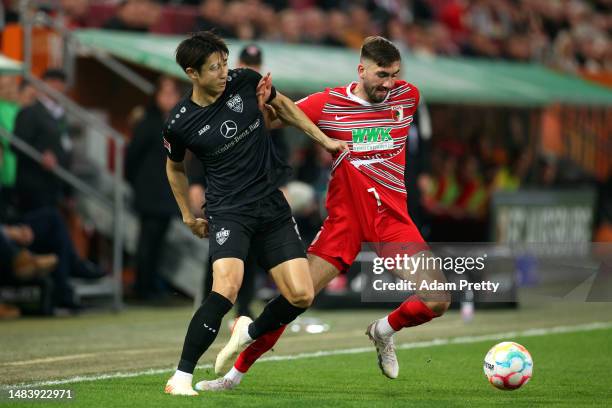 Hiroki Ito of VfB Stuttgart battles with Dion Drena Beljo during the Bundesliga match between FC Augsburg and VfB Stuttgart at WWK-Arena on April 21,...