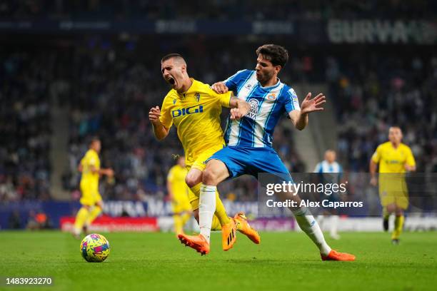 Sergi Guardiola of Cadiz CF is tackled by Leandro Cabrera of RCD Espanyol during the LaLiga Santander match between RCD Espanyol and Cadiz CF at RCDE...