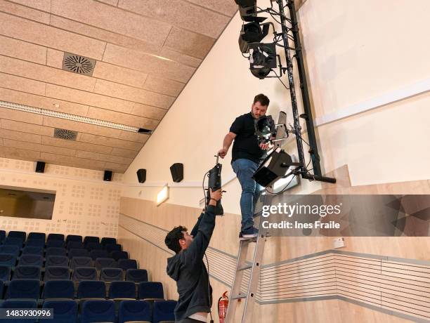 tontechniker auf einer leiter installieren scheinwerfer für eine musikalische darbietung - sound system stock-fotos und bilder