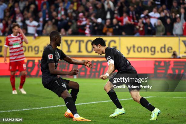 Wataru Endo of VfB Stuttgart reacts to scoring during the Bundesliga match between FC Augsburg and VfB Stuttgart at WWK-Arena on April 21, 2023 in...