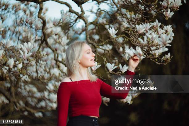 young woman in magnolia blossoms - magnolia stock-fotos und bilder