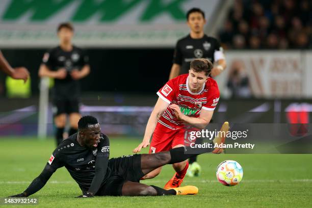 Silas Katompa Mvumpa of VfB Stuttgart clashes with Elvis Rexhbecaj of FC Augsburg during the Bundesliga match between FC Augsburg and VfB Stuttgart...